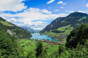 A breathtaking aerial view of a lake surrounded by mountains and a picturesque village in Switzerland.