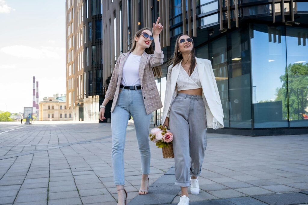 Two stylish women in sunglasses walking outdoors, embracing fashion trends.