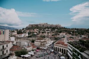 Stunning aerial view of Athens cityscape with iconic Acropolis under blue skies.
